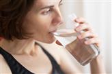 woman clasping a glass of water